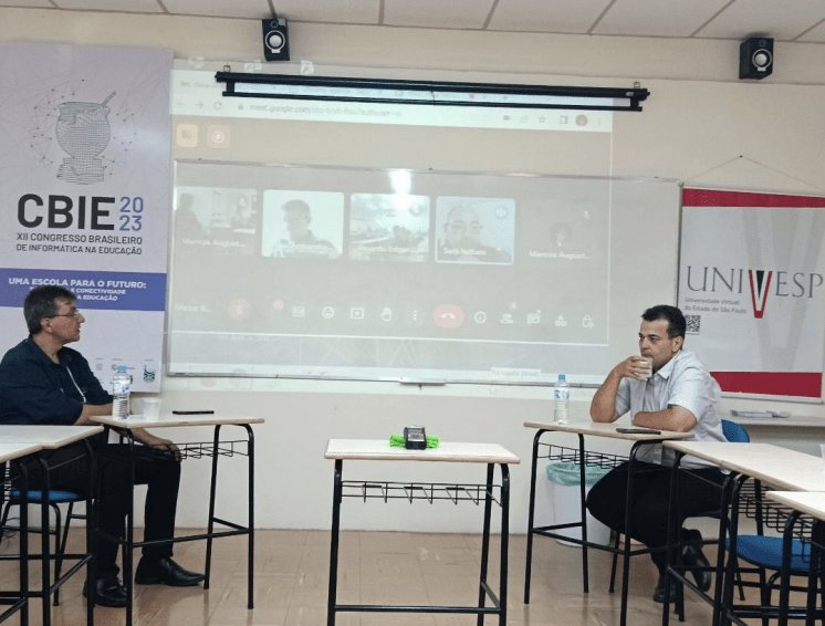 Meeting in a classroom with the President of UNIVESP and online participants