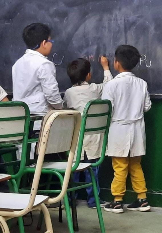 Children write on a black board