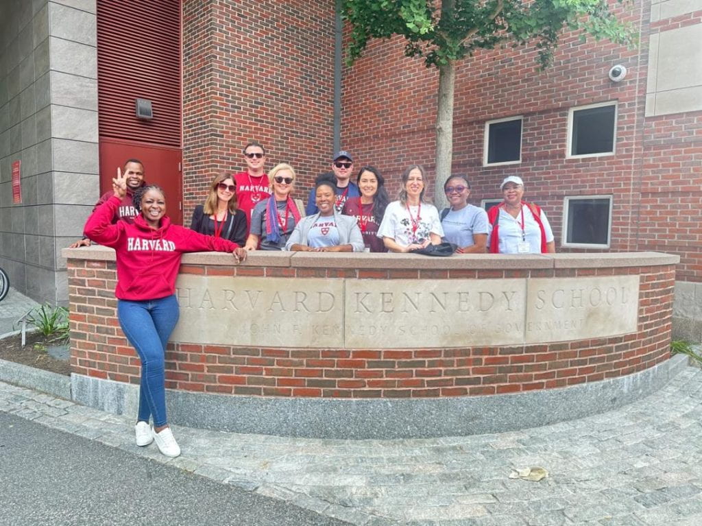 Group posing on campus with Harvard Kennedy School sign