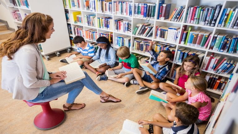 Children listen as a teacher reads to her students
