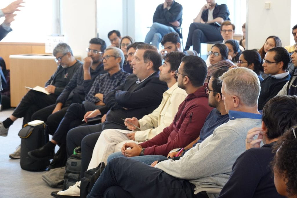 Audience members listening to Lant Pritchett speak