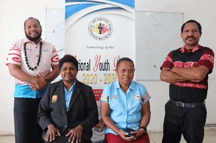 People standing and sitting in front of banner for National Youth Development Authority of Papua New Guinea