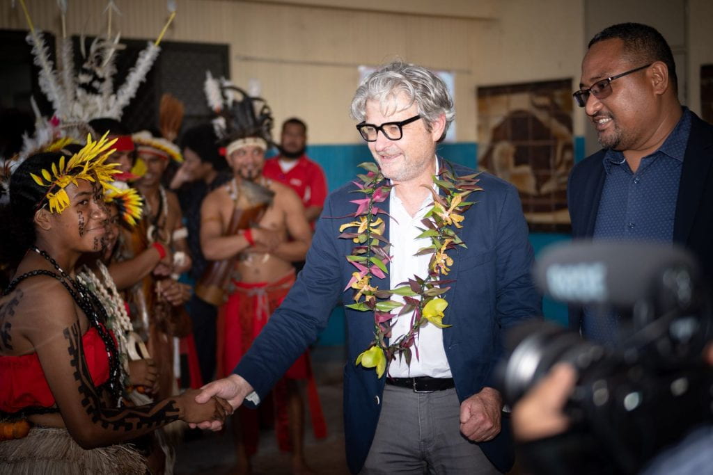 Matt Andrews shaking hands with a woman from Papua New Guinea