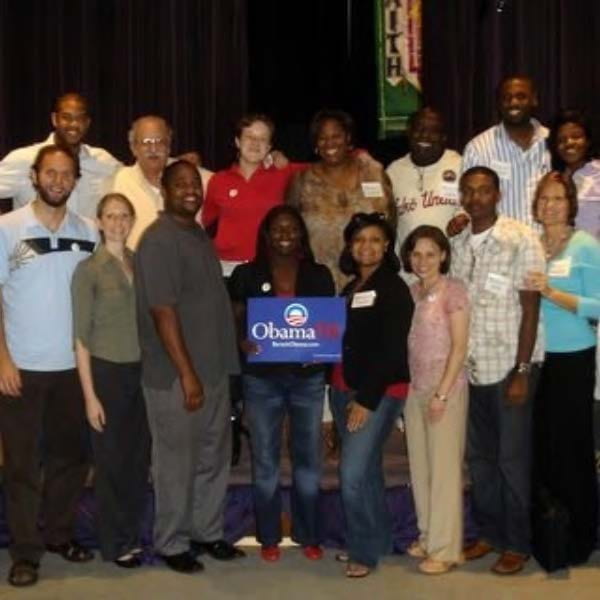 Marshall Ganz with others holding an Obama campaign sign