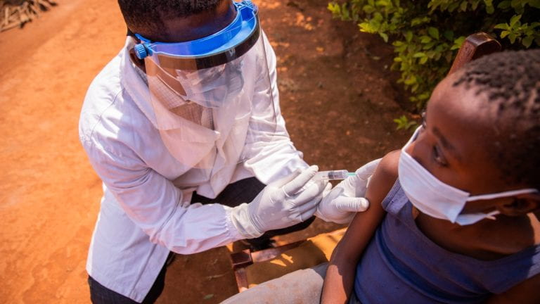 Healthcare worker injecting vaccine in Africa