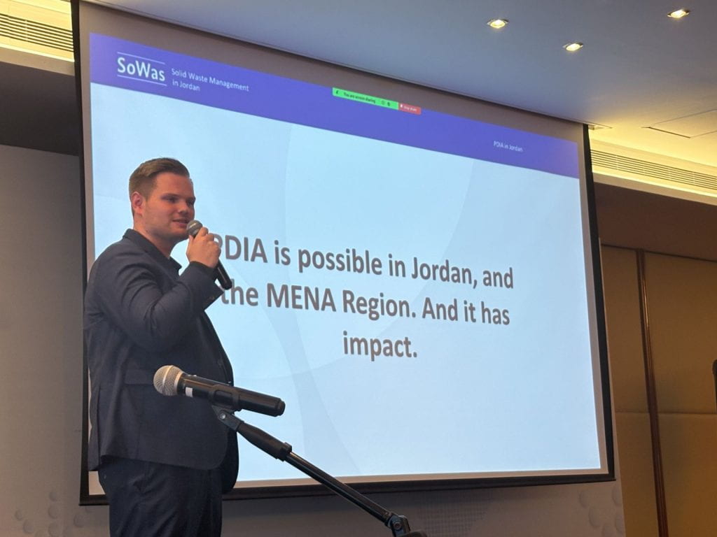 Tim presenting with slides in background