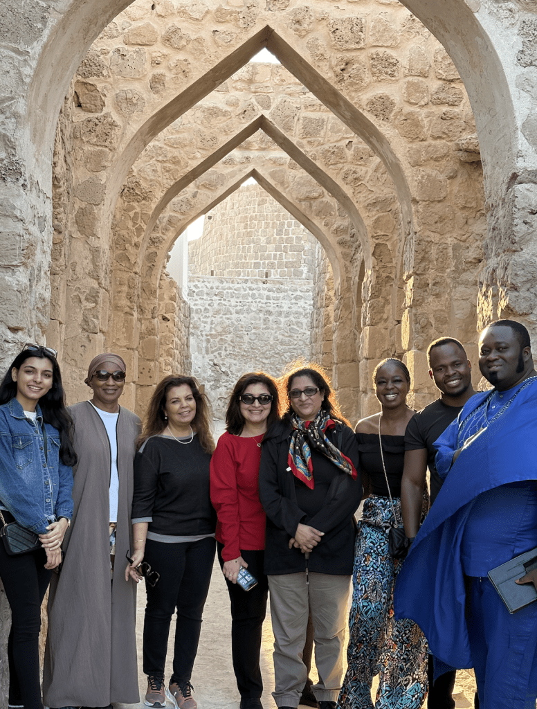 PDIA community members posing inside a fort with high arches