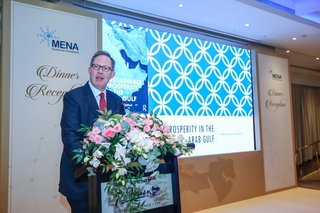 Dr. Jarmo Kotilaine presenting with podium and slides in background