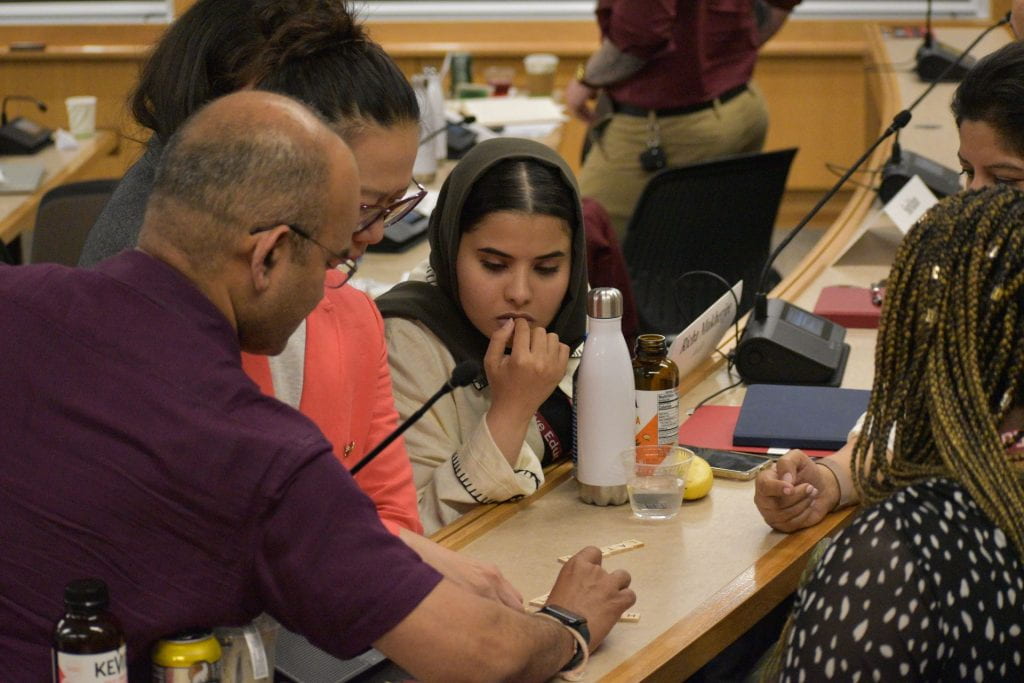 Participants looking at scrabble pieces on the counter