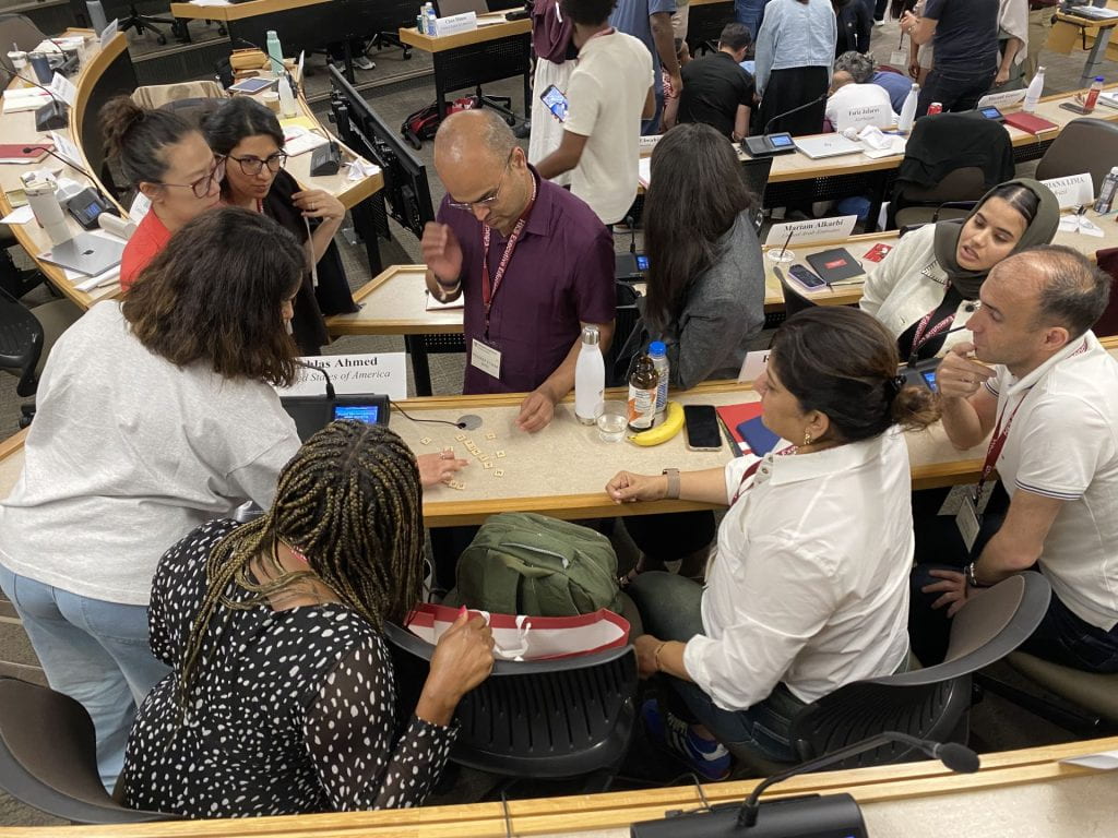 Participants working together on an exercise using scrabble pieces