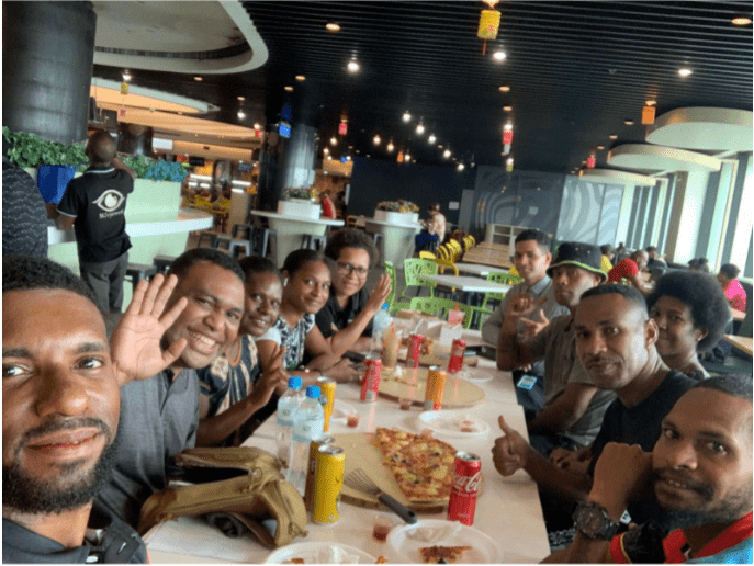 A group photo of team mobility minds sitting around a table at a restaurant.