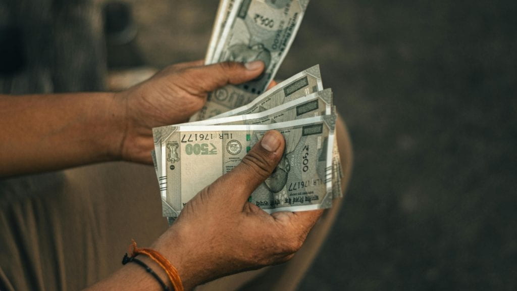 Hands holding rupees