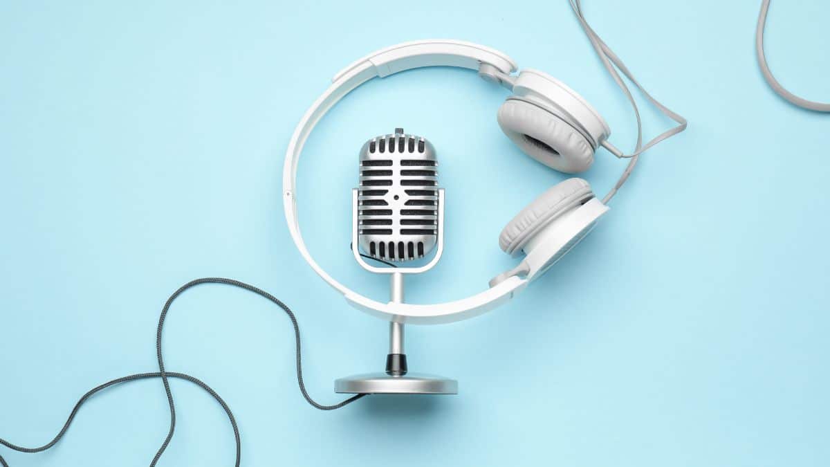Podcast microphone and headphones on blue background