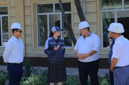 Volunteers outside conversing in hard hats.